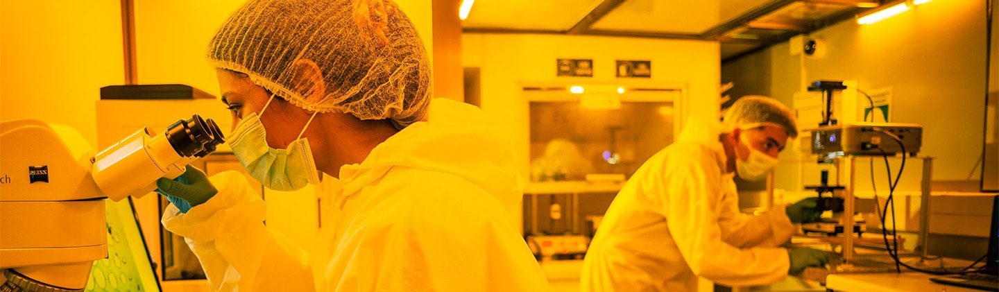 Brightly lit laboratory with researchers in protective gear conducting experiments.
